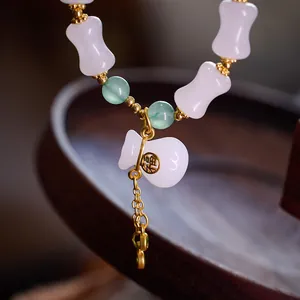 Green and white jade bamboo bead bracelet with a lucky Fu bag gold charm in Chinese style