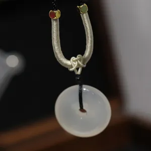 Macro shot of translucent white chalcedony pendant with detailed woven cord and beads