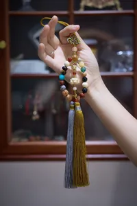 Detail of multi-gemstone prayer beads with lotus carving and elegant silk tassels
