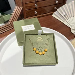 Close-up of yellow beaded necklace set in a vintage green velvet jewelry gift box