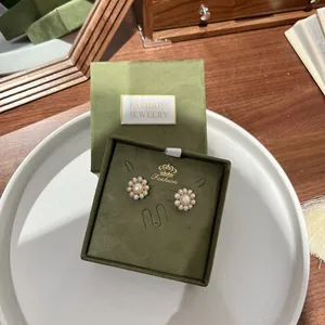 Retro pearl cluster earrings in green velvet gift box with crown logo detailing