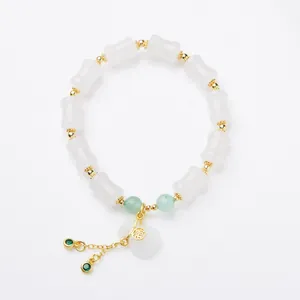 Bamboo style white jade bracelet with gold lucky pendant and green bead accents