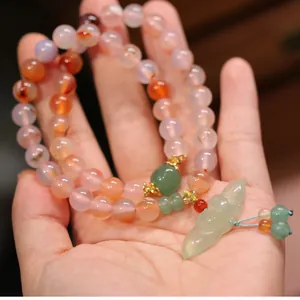 Natürliches 8mm Achatperlen-Armband mit Jade-Lotus-Anhänger in der Hand gehalten