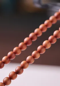 Macro shot of polished sandalwood beads and Hetian jade ring on a double-layer bracelet