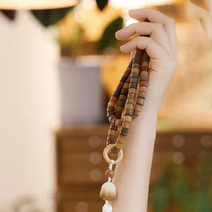 Handheld weathered bodhi seed prayer beads with lotus pendant and white tassel decor