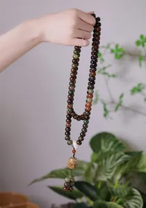 Detail of handcrafted bodhi seed prayer beads with vintage pendant and colorful stones
