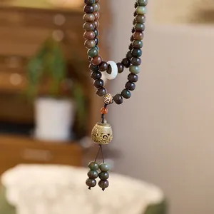 Macro detail of weathered white jade bodhi root beads and vintage hollow metal pendant