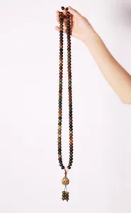Close-up of multicolored Bodhi seed prayer beads with a gold hollow pendant