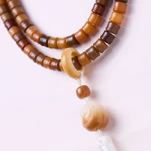 Macro shot of weathered white jade bodhi beads with silk tassel and floral pendant