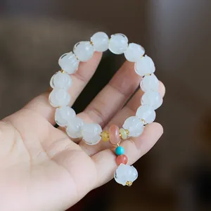 Detailed shot of handmade lotus-shaped beads on a Chinese-style beaded bracelet