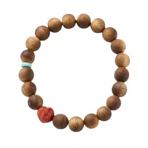 Bracciale in legno di agar naturale con un ciondolo rosso intagliato su sfondo bianco