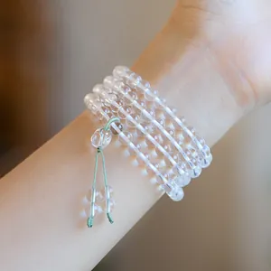 Transparentes 6mm Bergkristall-Armband mehrlagig mit hellgrüner Kordel am Handgelenk