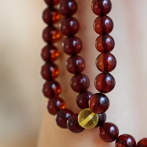 Bracelet de 108 perles d'ambre rouge cerise poli avec une perle d'accent jaune limpide