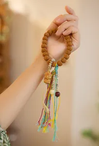 Detailopname van natuurlijke Rudraksha-kralen met fijn snijwerk en kleurrijke kwast