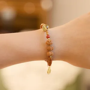 Pulsera retro de semillas de Bodhi con cuentas de ámbar y colgante dorado al pulso