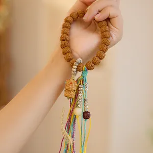 Natuurlijke Rudraksha Bodhi armband met handgesneden monnikshanger en kleurrijke kwast