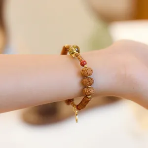 Pulsera retro de semillas de Bodhi y cristal en la muñeca con detalles dorados
