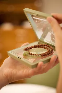Houten kralenarmband met groene jade steen in een PE-folie sieradendoosje gepresenteerd
