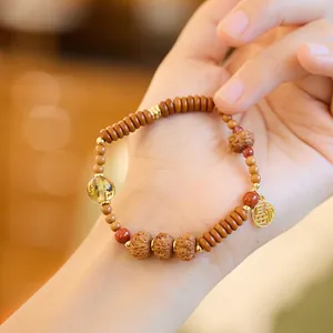Detalle de pulsera Bodhi con colgante Fu dorado y cuenta de citrino en la muñeca