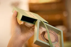 Macro-opname van een groene sieradendoos met een houten kralenarmband aan de binnenkant