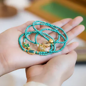 Gelaagde natuurlijke turquoise kralenarmband met gouden vlinder en jade hanger sieraad
