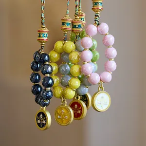 Ethnic religious style phone charms with colorful beads and golden prayer cylinders
