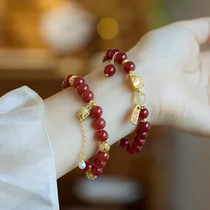 Détail du bracelet double rang en agate rouge avec chat porte-bonheur et perles