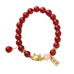 Bracelet en perles d'agate rouge naturelle avec breloques dorées et perle jaune