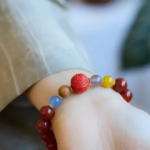 Gros plan détaillé d'un bracelet en agate veine de dragon avec perles et cinabre gravé