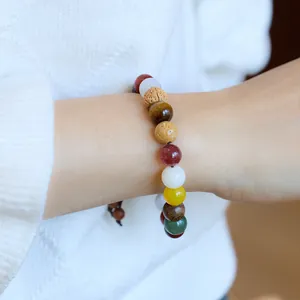 Détail de bracelet bouddhiste artisanal au poignet avec pierres naturelles et graines
