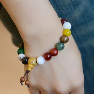 Gros plan d'un bracelet Bodhi à dix-huit graines avec perles colorées porté au poignet
