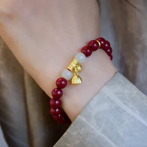 Bracelet en cinabre rouge avec breloques de lotus et jade blanc sur soie