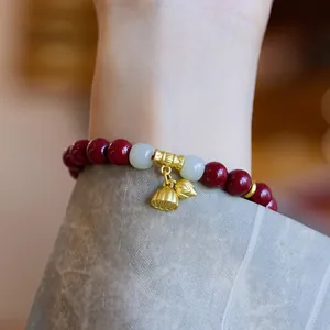 Vue détaillée du bracelet en cinabre avec perles de jade et pendentifs lotus dorés