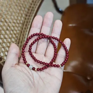 Détail d'un bracelet double couche en cinabre rouge avec perles d'argent et de jade