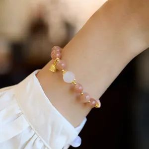 Natural sunstone bracelet with lily of the valley charm and lotus bead on model wrist