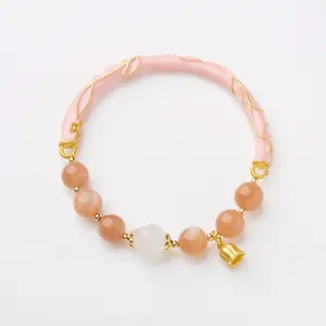 Pink sunstone bracelet with lily of the valley flower charm and golden leaf details