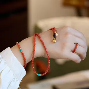 Σετ κοσμημάτων από κόκκινο αχάτη με τιρκουάζ χάντρες και χρυσό λωτό στο μοντέλο