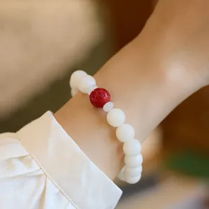 Macro view of white jade bodhi beads and cinnabar charm with auspicious engraving