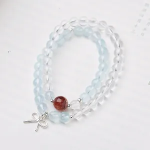 Détail du bracelet en perles d'argent S925 avec aigue-marine et breloque noeud en cristal