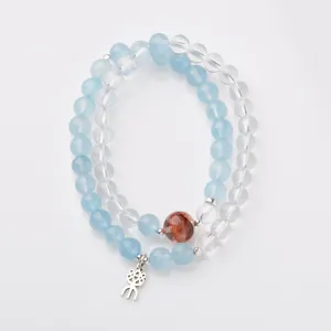 Bracelet double en aigue-marine et quartz avec breloque argentée sur fond blanc