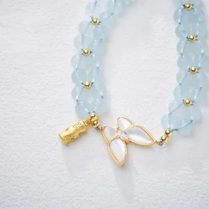 Bracelet tressé en aigue-marine naturelle avec breloques papillon et bambou dorés