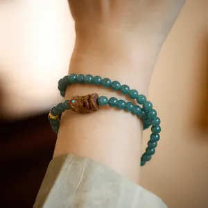 Bracelet en jade naturel double boucle avec perle en bois sculpté et détails dorés
