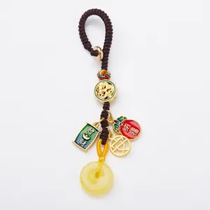 Traditional Chinese keychain with amber bead and golden dragon charm on white background