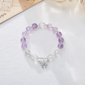 Elegant natural amethyst beaded bracelet featuring silver butterfly charm on white texture