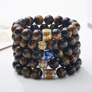 Stack of five natural tiger eye stone bracelets with golden charms and blue enamel beads