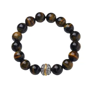 Tiger Eye stone bead bracelet with a silver vintage embossed metal charm on white background