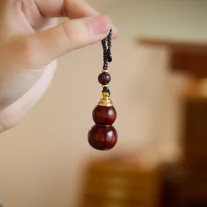 Sandalwood gourd keychain pendant with wood grain texture and handmade woven cord