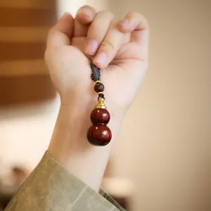 Sandalwood gourd keychain pendant with hand-woven cord and elegant metal accent