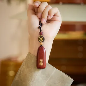 Handcrafted red sandalwood car keychain with gold Chinese seal carving and braided rope