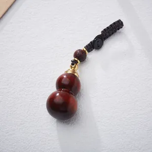 Handcrafted rosewood gourd keychain with hand-woven rope and intricate wooden bead detail